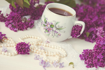 Obraz na płótnie Canvas a cup of tea or coffee with a pattern in lilac bouquet of lilacs