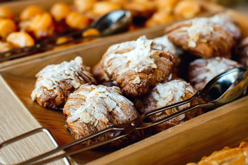 Croissants sprinkled with almonds, powdered suga