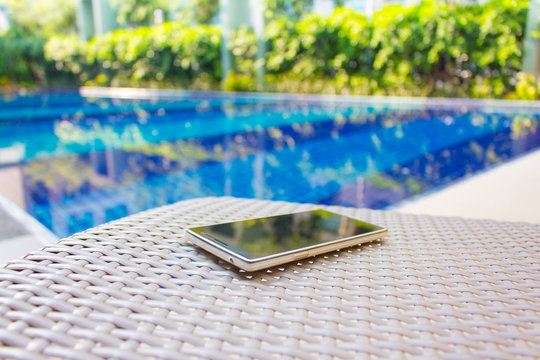 Smartphone put on armchair beside the pool
