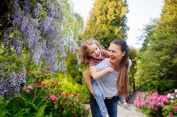 Mother and daughter walking in the summer park