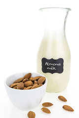 Almond milk and almonds, on white background