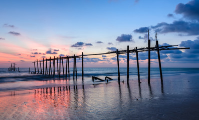 Beautiful sunset beach with abandoned wooden pier