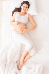 Obraz premium Pretty pregnant woman is relaxing at home