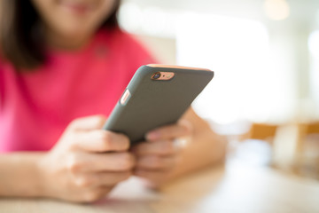 Woman using mobile phone at cafe