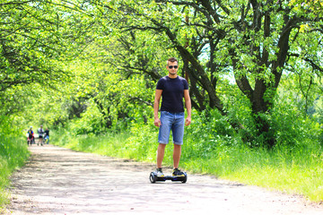 man riding electrical scooter, hoverboard, gyro scooter, gyroboard, smart balance wheel - personal portable eco transport