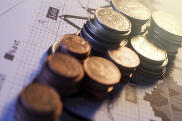 Stacks of varying heights of coins with chart