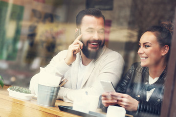 Happy couple using phones