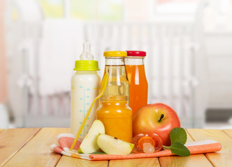 Obraz na płótnie Canvas Bottles with milk, juices, fruit puree bank against backdrop kitchen.