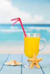 Glass  juice with  straws and  starfish on  background  sea landscape.