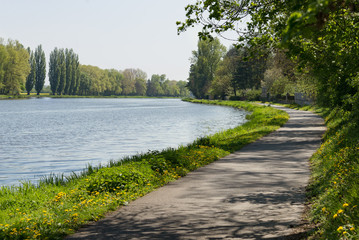 Fototapeta premium Bike lane bicycle cycle path by the river green trees EU supported project Brandys Labe