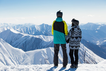 Couple in love snowboarder snowboarding on fresh white snow on ski slope on Sunny winter day