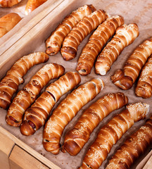 Hot dog with sesame seeds on shelf in Bakery shop. Pastries and bread in a bakery