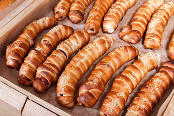 Hot dog with sesame seeds on shelf in Bakery shop. Pastries and bread in a bakery