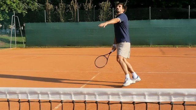 man tennis player smashing and celebrates point on a red clay court slow motion professional