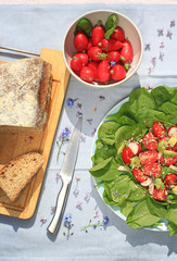 Fresh, home baked soda bread on wooden cutting board and frehs vegetarian salad