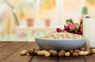 Bowl  oatmeal,  glass  milk and nuts on  background the kitchen.
