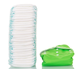 Stack of disposable and one reusable diaper  isolated on white.