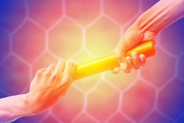 hands passing a relay baton on on soccer goal net background with vintage color tone effect.