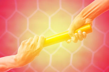 hands passing a relay baton on on soccer goal net background with vintage color tone effect.