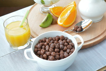 Grain balls, orange and kiwi fruit - dry breakfast on the table