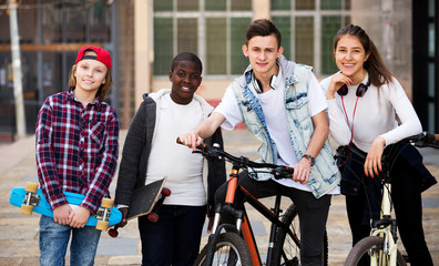 Teenagers with skateboards posing in town square