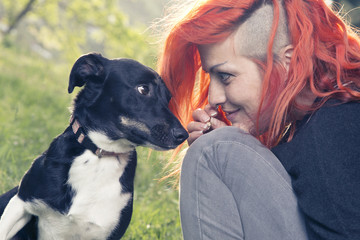 Happy punk woman playing with her dog.