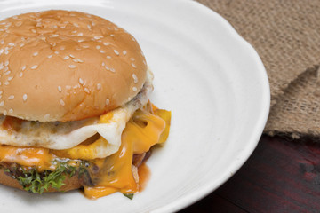 hamburger in plate on wood table.