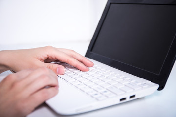 woman using laptop and writing on keyboard