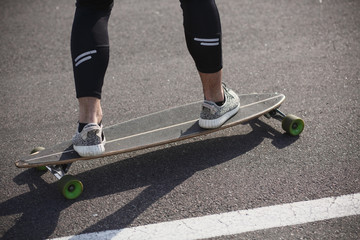 Man riding on longboard skate on road through forest or city. Man's legs on skateboard or longboard. © Svyatoslav Lypynskyy