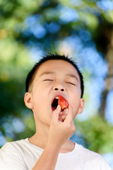 Boy eat strawberry
