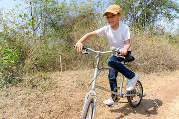 Fototapeta na wymiar Little boy ride bicycle on the rock road.