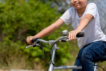 Obraz premium Little boy ride bicycle on the rock road.