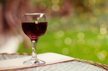 Glass of red wine on a table on a green background