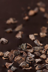 Closeup of dark chocolate with pieces of cocoa beans