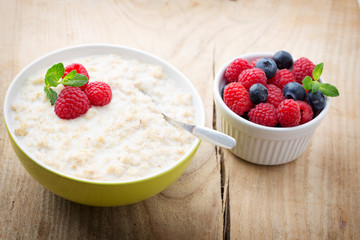 Oatmeal porridge in bowl with berries raspberries and blackberri