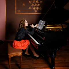 Young woman musician writes in music book pencil.