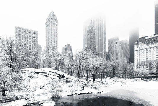 Fototapeta Staw w Central Parku w mglisty zimowy poranek widziany z mostu Gapstow. Niskie chmury pokrywają drapacze chmur na Manhattanie