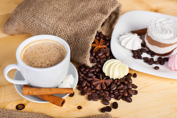 cup of coffee and coffee beans on a wooden surface