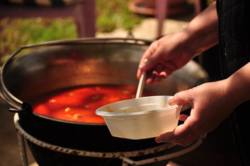 Traditional Goulash soup is cooking in the a cauldron