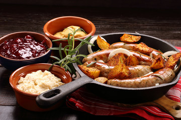 Grilled sausages with barbecue sauce baked in a frying pan