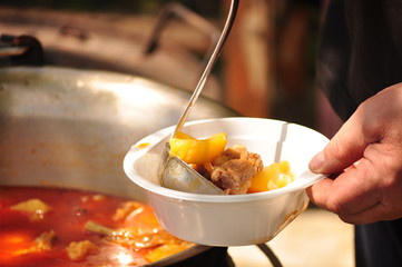 Traditional Goulash soup is cooking in the a cauldron