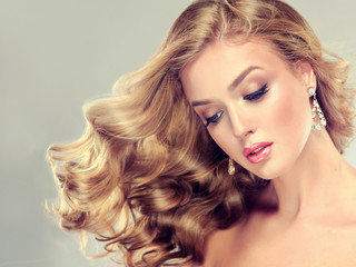 Beautiful girl  blonde hair with an elegant hairstyle , hair wave ,curly hairstyle . Jewellery , earrings and bracelet © edwardderule