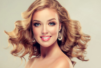 Beautiful girl  blonde hair with an elegant hairstyle , hair wave ,curly hairstyle . Jewellery ,...