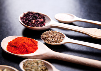 spice in wood spoon on a black background. food