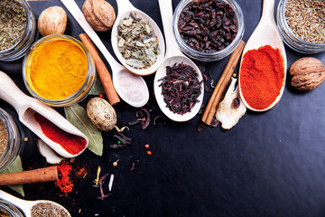Spices on black background in special jars. Food