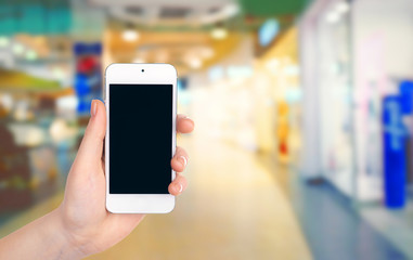 Female hands shows mobile smart phone, blurred background