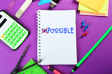 Word impossible transformed into possible on notebook page with school supplies
