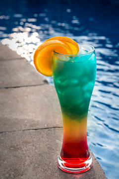 Fun summertime rum drink by the pool topped with orange slices