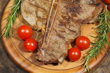 Grilled T bone steak with rosemary tomatoes, corn, onions and as