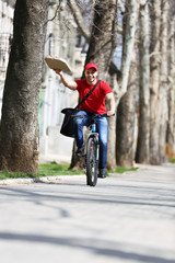 Young man with bike delivering pizza